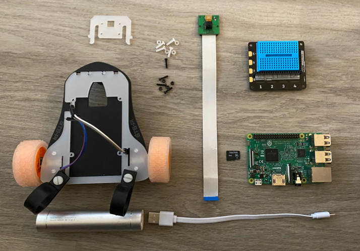 A Pimoroni STS-Pi robot kit, Explorer Hat, Raspberry Pi, camera, and battery.