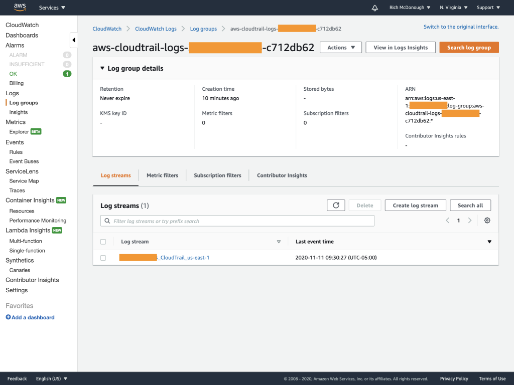 Log group details include retention (Never expire), creation time (10 minutes ago), stored bytes, ARN, KMS key ID, metric filters, and more.