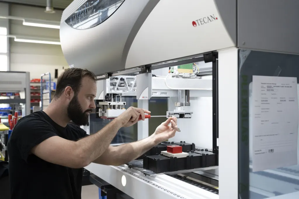 Tecan Engineer working on a complex laboratory automation system or device