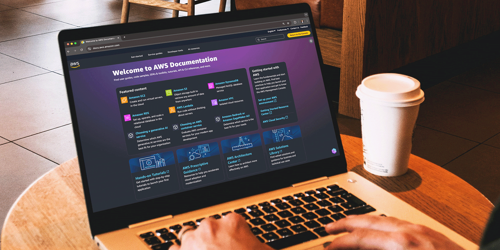 Person in cafe viewing AWS docs website on a laptop