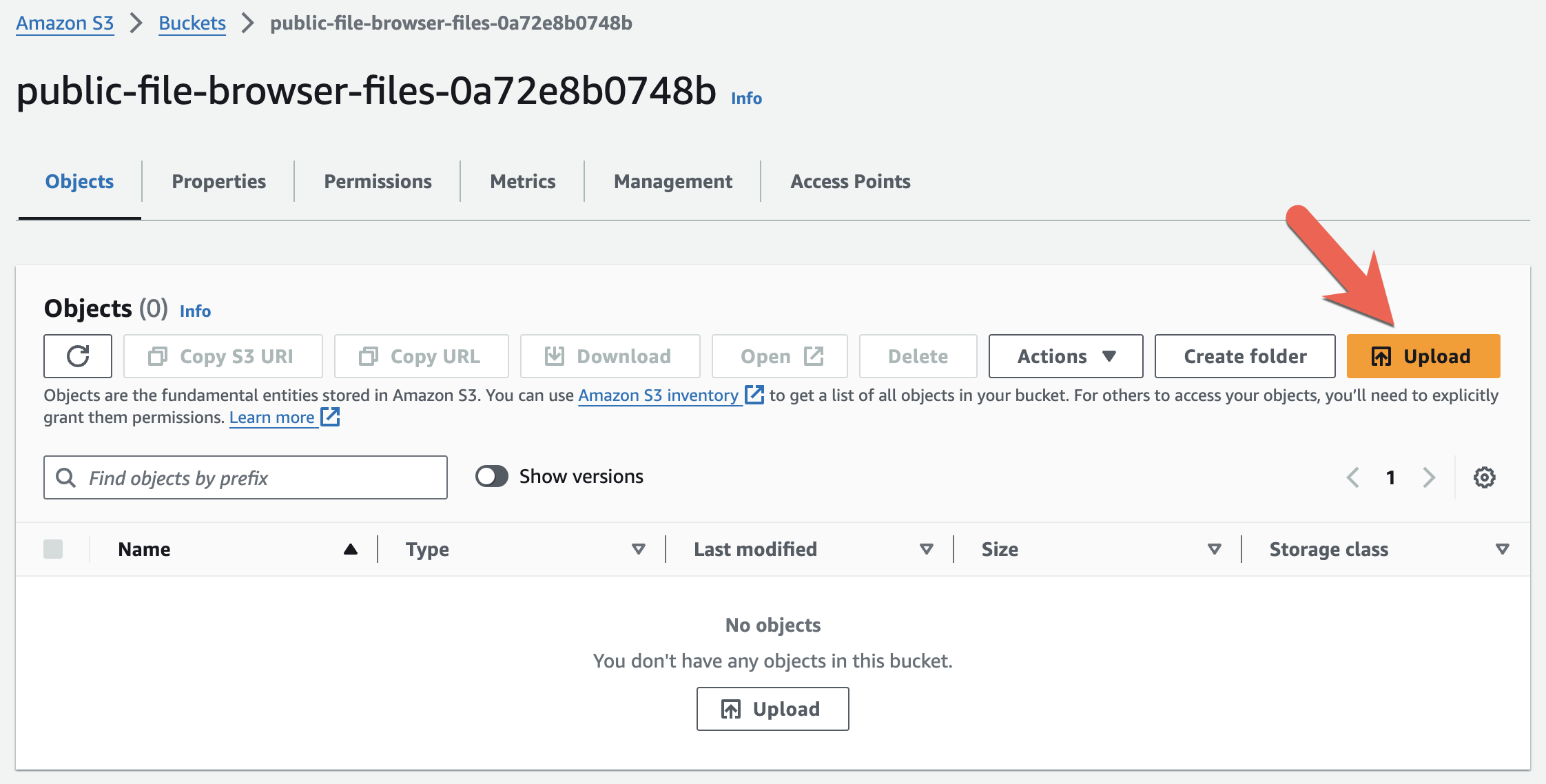 A screenshot of the AWS Management Console's S3 Bucket contents view. The bucket is the bucket for public files and is empty. There is an arrow pointing to the Upload button.