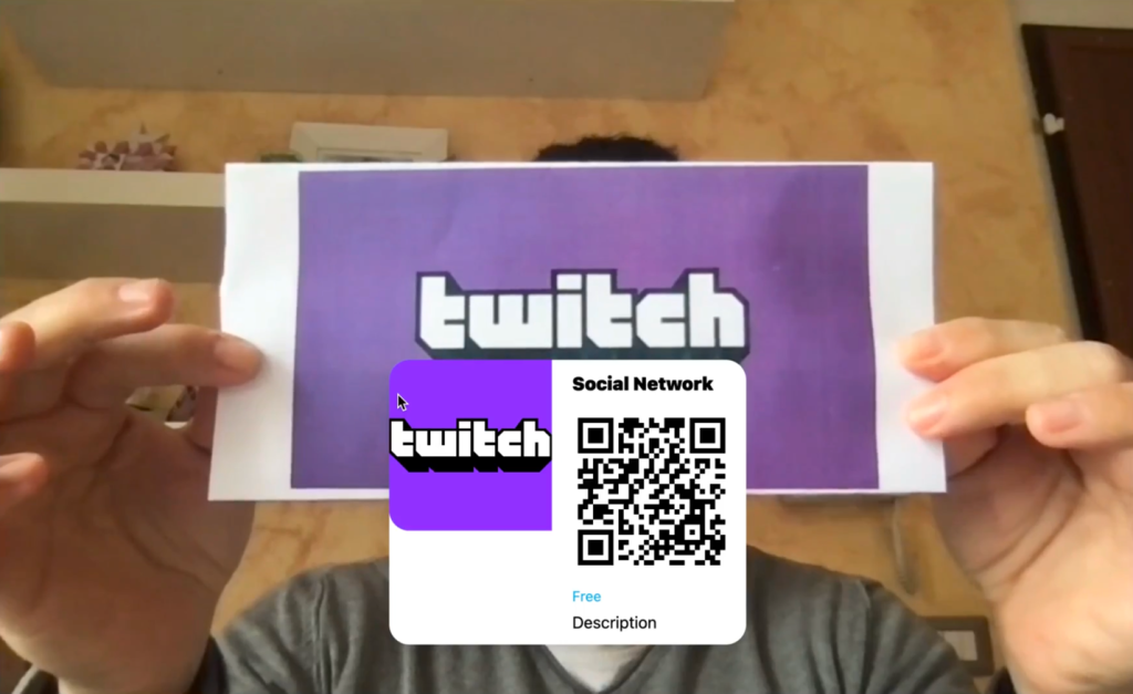Person holding piece of paper with Twitch logo on it, recognized.