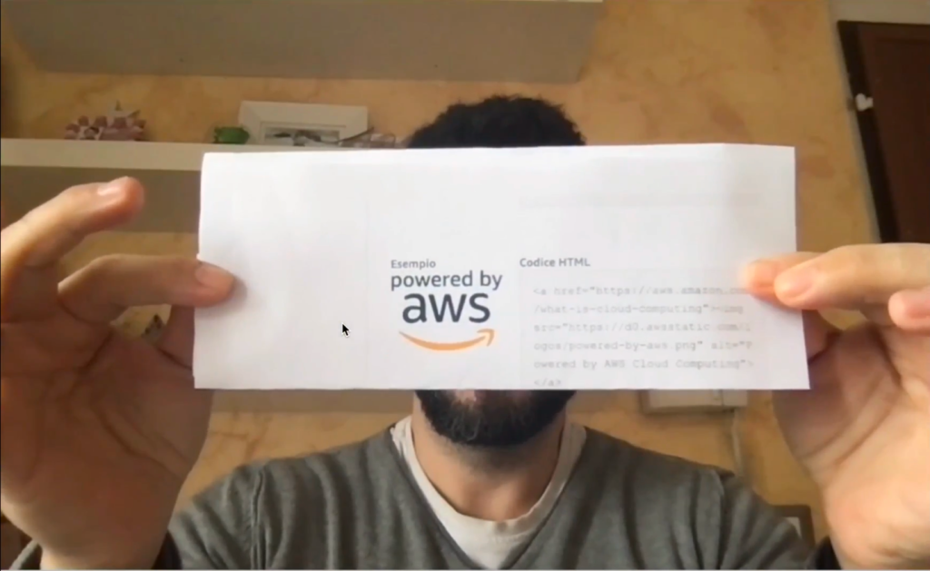 Person holding piece of paper with AWS logo detected on it.